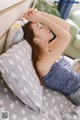 A woman laying on a bed with her head on a pillow.