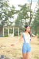 A woman in a blue and white checkered romper on a beach.