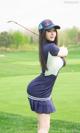 A woman in a blue and white uniform holding a golf club.