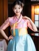 A young girl wearing a pink and blue hanbok.