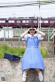 A woman in a blue dress is posing for a picture.