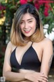 A woman in a black bikini posing for a picture.