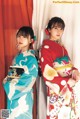 Two young women in kimonos standing next to each other.