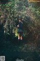 A woman standing in the middle of a forest.