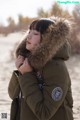 A woman in a parka with a fur hood on her head.