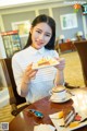 A woman sitting at a table with a plate of food.